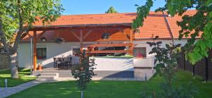 a house with an orange roof and a patio at Alpakavendégház in Balatoncsicsó +8 photos
