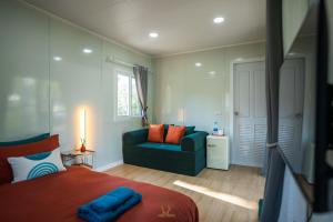 a bedroom with a bed and a blue couch at Kood Friends Koh Kood in Ko Kood