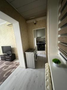 a living room with a refrigerator and a kitchen at Уют как дома in Shymkent