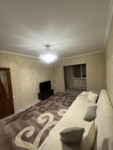 a bedroom with a large bed and a television at Уют как дома in Shymkent