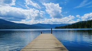 a wooden pier on a lake with mountains in the background at The Coolin Motel in Coolin