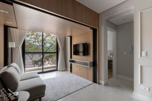 a living room with a tv and a couch and a window at 1986 Apparts in Águas de São Pedro +31 photos