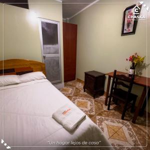 a bedroom with a bed and a table and a desk at Chaska Backpackers & Rooms in Ayacucho