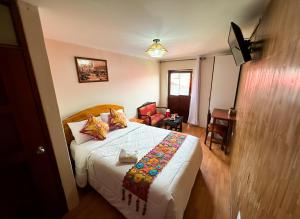 a bedroom with a bed and a chair in a room at Chaska Backpackers & Rooms in Ayacucho