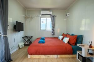 a bedroom with a large red bed and a window at Kood Friends Koh Kood in Ko Kood