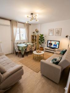 a living room with a couch and a table and a tv at El caserío de la abuela in Cabezuela del Valle