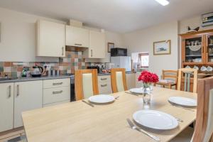 a kitchen with a table with plates and flowers on it at Wolds View in Cornisholme