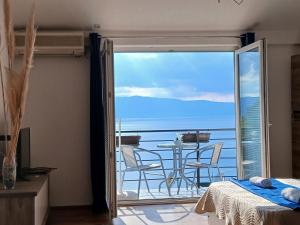 a bedroom with a balcony with a view of the ocean at Lake Breeze Aparments - Trpejca in Trpejca