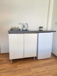 a white counter with a black counter top on top at Lake Breeze Aparments - Trpejca in Trpejca