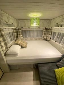 a small bed in the back of a rv at Camping Abordaż Wolin in Kołczewo