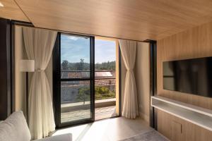 a room with a large window with a view at 1986 Apparts in Águas de São Pedro