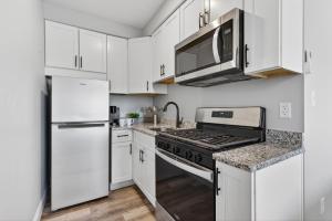 a white kitchen with a stove and a microwave at The Beach House in Wildwood