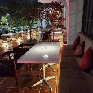 a table and couch on a patio with tables and chairs at Hotel Reina Isabel in Quito