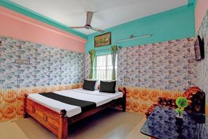 a bedroom with a bed in a room with colorful walls at Hotel O Green House in Lālbāgh