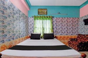 a bedroom with a bed and a window at Hotel O Green House in Lālbāgh +37 photos