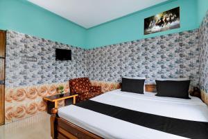 a bedroom with a bed and a chair at Hotel O Green House in Lālbāgh