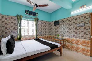a bedroom with a bed and a window at Hotel O Green House in Lālbāgh