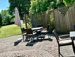 eine Terrasse mit Tisch, Stühlen und Sonnenschirm in der Unterkunft Hotel Spitze Warte in Rüthen + 10 Fotos