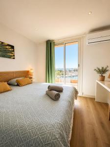 a bedroom with a large bed with a large window at Loft Marina in Cogolin