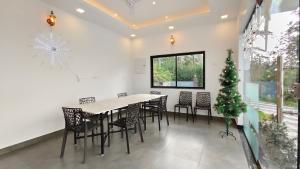 a dining room with a table and chairs and a christmas tree at Vaango Cottages in Idukki +50 photos