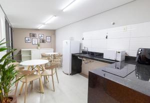 a kitchen with tables and chairs in a room at MOOVE Stay - Suite Cacau no centro in Uberlândia