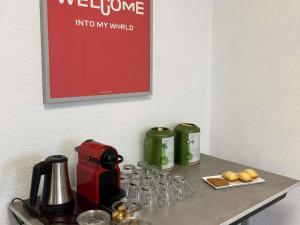 a counter with glasses and a coffee maker on it at Ibis Brive Centre in Brive-la-Gaillarde
