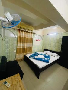 a small room with a bed and a fan at Hotel Al Fahad in Dhaka