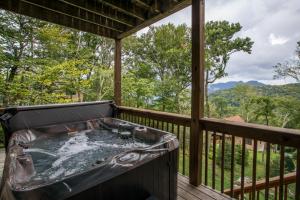 a hot tub on the deck of a house at Sugar Bear in Sugar Mountain