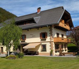 a house with a gambrel roof with a balcony at Haus Garz in Weissensee
