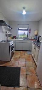 a kitchen with a tile floor and a large window at Bridie's Cottage in Mullagh