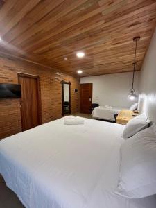 a large white bed in a room with wooden ceilings at Encanto Rural in Bella Vista +40 photos