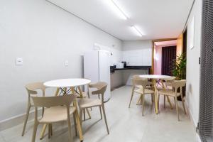 a room with two tables and chairs and a kitchen at MOOVE Stay - Suite Cacau no centro in Uberlândia