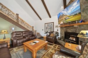 a living room with leather furniture and a stone fireplace at Four Diamond Escape in Seven Devils