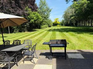 a picnic table and chairs with a grill and a field at Royal Windsor Country Estate Private 5 Acres of Gardens in Windsor +29 photos