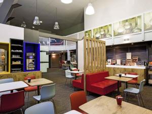 a restaurant with tables and chairs and a counter at Ibis Provins in Provins