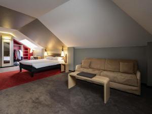 a living room with a bed and a couch at ibis Montargis in Montargis +121 photos