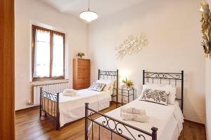 a bedroom with two beds and a window at La Dimora degli Olivi in Torrita di Siena