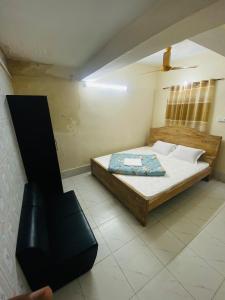 a bedroom with a bed and a black chair at Hotel Al Fahad in Dhaka
