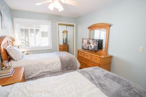 a bedroom with two beds and a dresser with a mirror at Condo at Pinnacle Inn Resort in Beech Mountain +13 photos