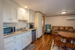 a kitchen and living room with a table and a couch at Fern Cottage in Beech Mountain