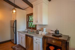 a kitchen with white cabinets and a sink and a refrigerator at Fern Cottage in Beech Mountain