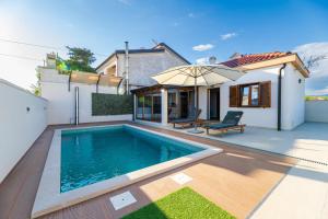 a swimming pool in the backyard of a house at Holiday house "Maria" in Privlaka