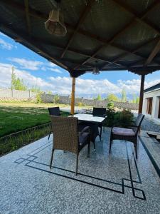 a patio with a table and chairs under a roof at Raku Guest House - A Peaceful Stay in the Heart of Leh in Leh