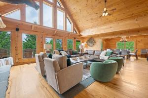 a living room with a lot of furniture and windows at Alpine Ridge in Banner Elk