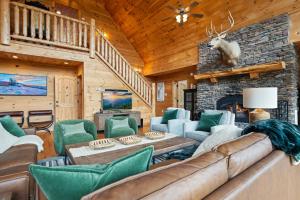a living room with a couch and a stone fireplace at Alpine Ridge in Banner Elk