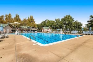 a large swimming pool with chairs and an umbrella at Bear Trap Dunes - 182 Willow Oak in Ocean View