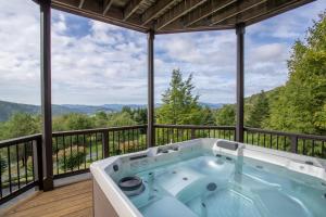 a hot tub on a deck with a view of the mountains at The Retreat at Mountain Meadows in Banner Elk