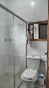 a bathroom with a toilet and a glass shower at Pousada dos Cuiabás in Tiradentes