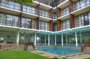 an external view of a building with a swimming pool at Rain Tree by Oak Ray in Tissamaharama
