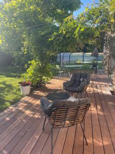 two chairs and a table on a wooden deck at 15 min from Lyon Fresh Peaceful Room with Pool and Garden in Dardilly